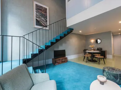 a living room with a staircase and a dining room at Apartamentos The Arc Carrís in Porto