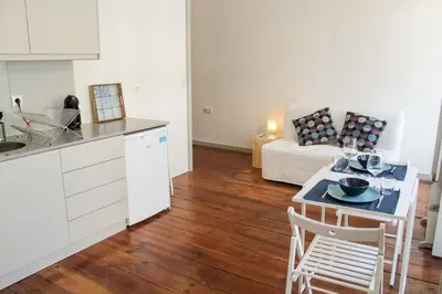 a kitchen and living room with a table and a couch at Bonjardim Flats - T1 com varanda in Porto