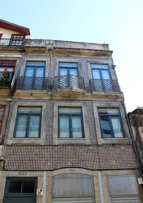 a tall brick building with windows and balconies at Bonjardim Flats - T1 com varanda in Porto