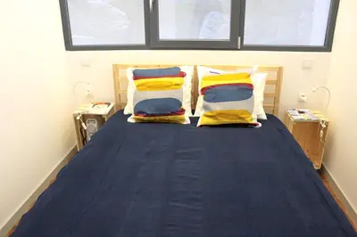 a bedroom with a blue bed with yellow pillows at Bonjardim Flats - T2 com Varanda in Porto