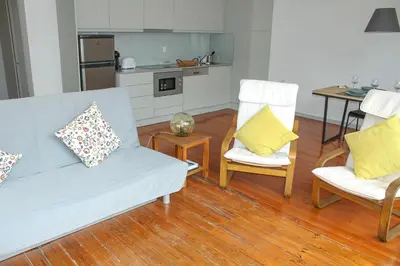 a living room with a couch and two chairs and a table at Bonjardim Flats - T2 com Varanda in Porto