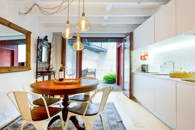 a kitchen and dining room with a wooden table and chairs at Porto Emotions - Caldeireiros in Porto