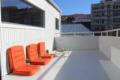 two orange chairs and a table on a balcony at Bonjardim Flats - T1 + 1 com terraço in Porto