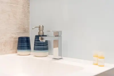 a bathroom sink with a faucet and two soap dispensers at GuestReady - Chic retreat in the heart of Porto in Porto