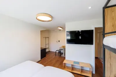 a living room with a bed and a flat screen tv at Cosme Apartments by Olala Homes in Porto