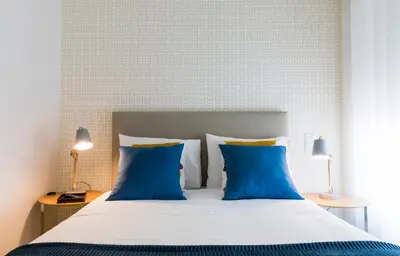 a bedroom with a bed with blue pillows at Oporto up Town in Porto
