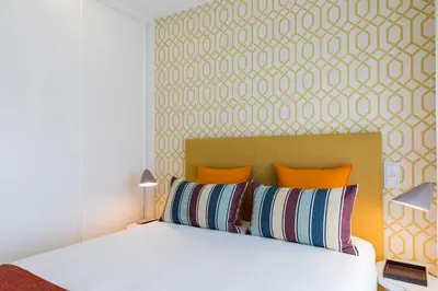 a bedroom with a large white bed with orange pillows at Oporto up Town in Porto