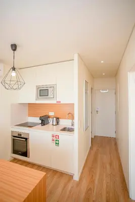 a kitchen with white cabinets and a wooden floor at Liiiving in Porto | Downtown View Apartment in Porto