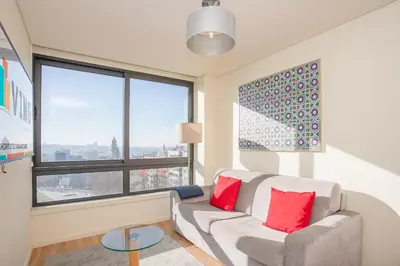 a living room with a couch and large windows at Liiiving in Porto | Downtown View Apartment in Porto