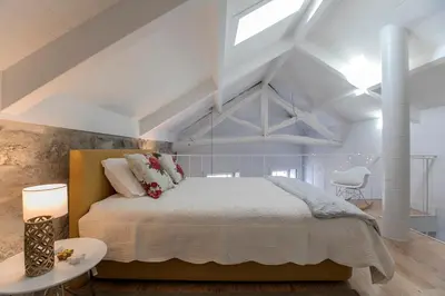 a bedroom with a large bed and a white ceiling at Mouzinho Cosy LOFT in Porto