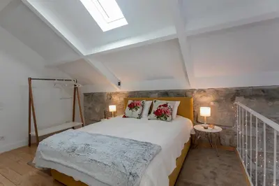 a bedroom with a large bed and a skylight at Mouzinho Cosy LOFT in Porto