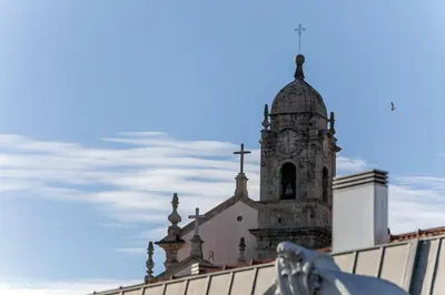 a church with a clock tower on top of a building at Mouzinho Cosy LOFT in Porto