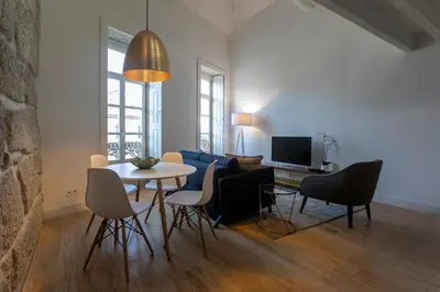 a living room with a table and chairs and a couch at Mouzinho Cosy LOFT in Porto