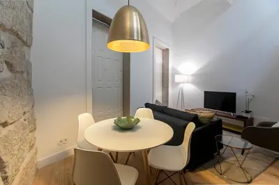 a living room with a table and chairs and a couch at Mouzinho Cosy LOFT in Porto