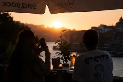 a group of people taking pictures of the sunset at Porto View by Patio 25 in Vila Nova de Gaia