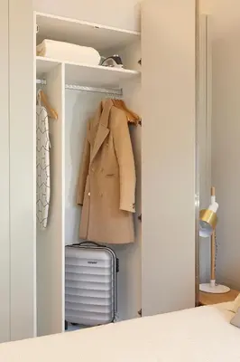 a closet with a coat and a suitcase at LOFT Sá de Noronha in Porto