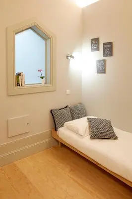 a small bedroom with a bed and a window at LOFT Sá de Noronha in Porto
