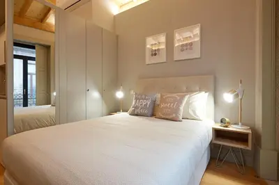 a bedroom with a large white bed with two lamps at LOFT Sá de Noronha in Porto