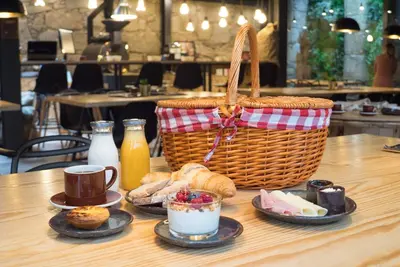 a table with a basket and plates of food and bread at 7 Gaia Roaster Apartments in Vila Nova de Gaia