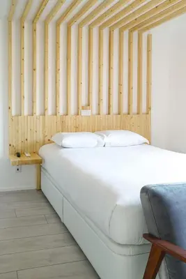 a bedroom with a white bed and a chair at 7 Gaia Roaster Apartments in Vila Nova de Gaia