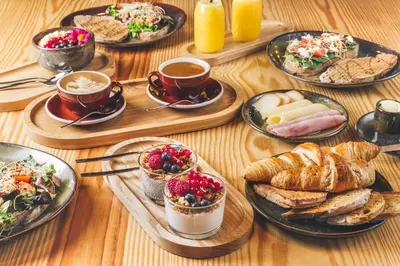 a table topped with plates of food and cups of coffee at 7 Gaia Roaster Apartments in Vila Nova de Gaia