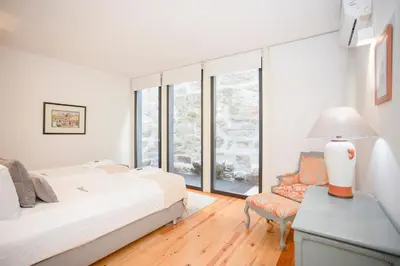 a bedroom with a bed and a desk and a window at Liiiving in Porto | Central Secret Terrace in Porto
