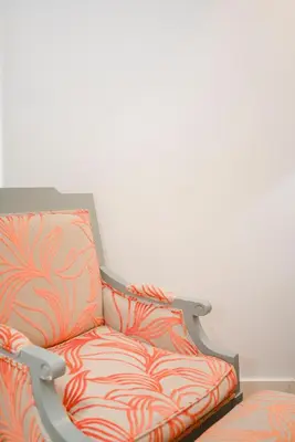 an orange chair against a white wall at Liiiving in Porto | Central Secret Terrace in Porto