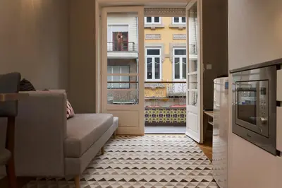 a living room with a couch and an open door at De Porto e Alma in Porto
