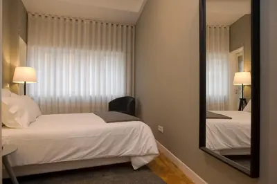 a bedroom with two beds and a mirror at De Porto e Alma in Porto