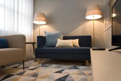 a living room with a blue couch and two lamps at De Porto e Alma in Porto