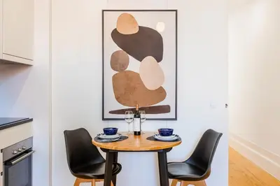 a black console table with a mirror on a white wall at BnBird Lifestyle Studio in Porto in Porto