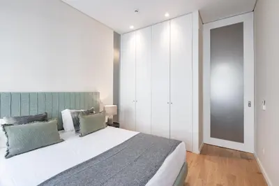 a bedroom with a large bed with a green headboard at VIVA 4 Suites Batalha Residence & SIZE Flats Batalha in Porto