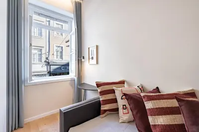 a living room with a couch and a window at VIVA 4 Suites Batalha Residence & SIZE Flats Batalha in Porto