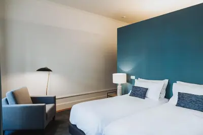 a hotel room with two beds and a blue wall at VIVA 4 Suites Batalha Residence & SIZE Flats Batalha in Porto