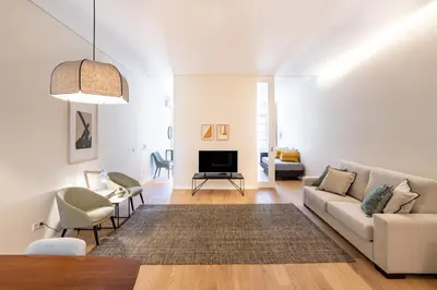 a living room with a couch and a tv at VIVA 4 Suites Batalha Residence & SIZE Flats Batalha in Porto