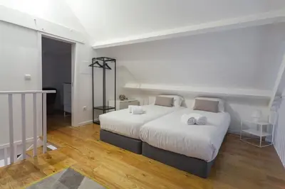 a bedroom with a large white bed with two pillows at Oporto City View - Santa Catarina in Porto