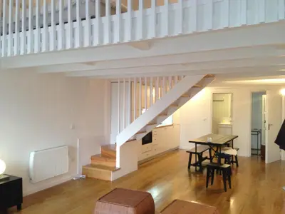 a living room with a staircase and a table and chairs at Oporto City View - Santa Catarina in Porto