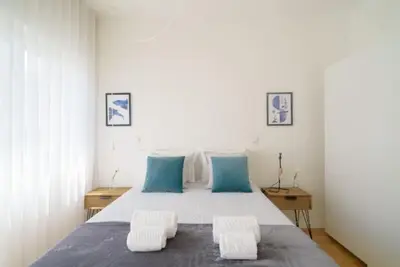 a bedroom with a large bed with two blue pillows at LAZ apartment in Porto
