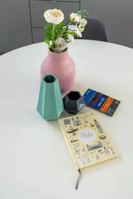 a pink vase with flowers and a book on a table at LAZ apartment in Porto