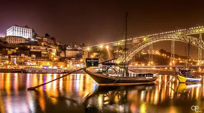 a boat is docked in the water in front of a bridge at LAZ apartment in Porto