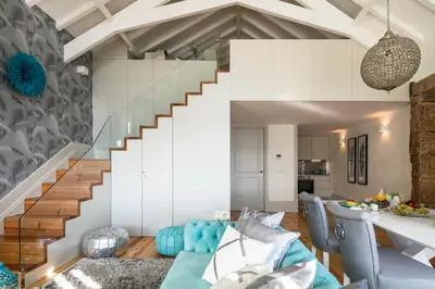 a living room with a blue couch and a staircase at Oporto Platinum Loft in Porto