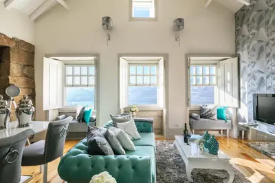a living room with a blue couch and a table at Oporto Platinum Loft in Porto