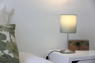 a lamp sitting on a nightstand next to a bed at Green House / Casa Verde in Porto
