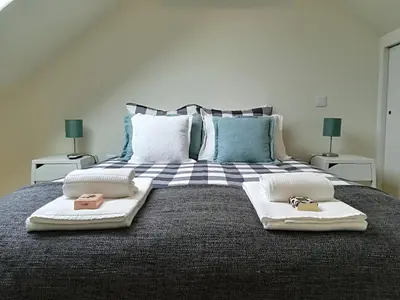 a bedroom with a bed with two towels on it at Green House / Casa Verde in Porto
