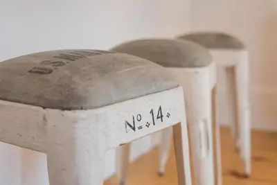 a row of three white stools with gray seats at GuestReady - Chic city nest in Porto in Porto