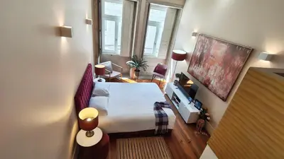 a bedroom with a large bed and a flat screen tv at Domus 21 - Formosa in Porto