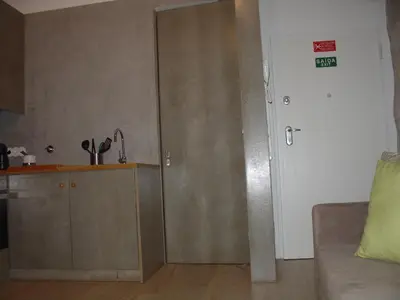 a living room with a door and a kitchen with a couch at Downtown Historical Apartment in Porto