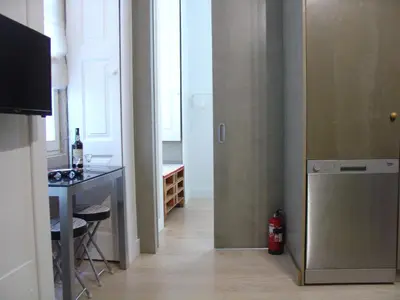 a room with a kitchen with a refrigerator and a table at Downtown Historical Apartment in Porto