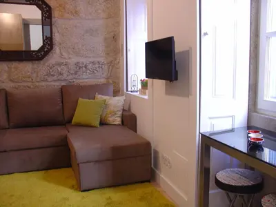 a living room with a couch and a mirror at Downtown Historical Apartment in Porto