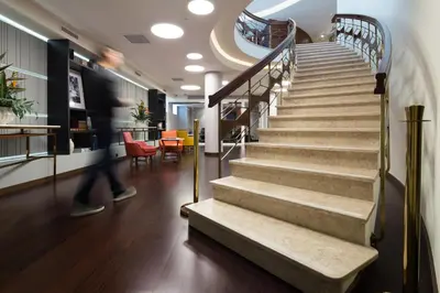 a staircase in a building with a person walking down it at Pestana Porto - A Brasileira, City Center & Heritage Building in Porto